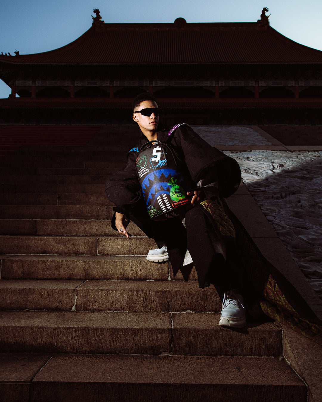 Sprayground - शार्क सेंट्रल एक्स डीएलएक्सएसवी पीठ बैग आउटलेट