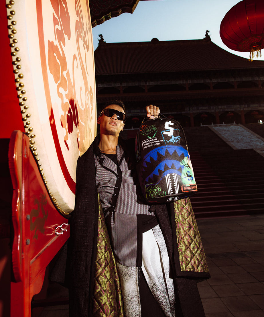 Sprayground - शार्क सेंट्रल एक्स डीएलएक्सएसवी पीठ बैग आउटलेट