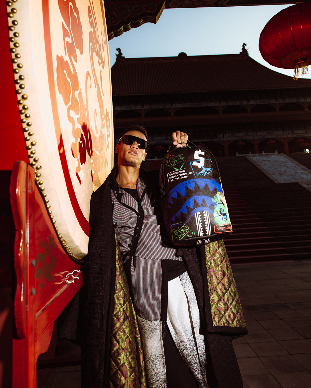 Sprayground - शार्क सेंट्रल एक्स डीएलएक्सएसवी पीठ बैग आउटलेट